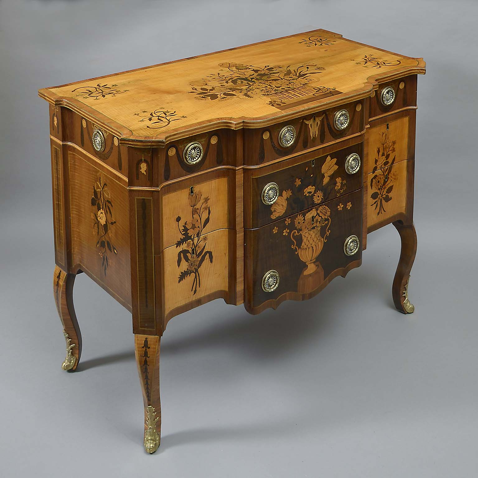 AN IMPORTANT MATCHED PAIR OF IRISH GEORGE III SYCAMORE, AMARANTH AND MARQUETRY COMMODES